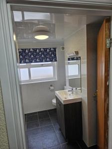 a bathroom with a sink and a toilet and a window at Castle By The Sea Scarborough in Scarborough +59 photos