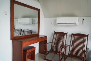 a mirror and two chairs in a room at Mirage Waterfall Villa in Talawakele