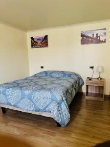 a bedroom with a bed with a blue comforter at Departamento Calama in Calama