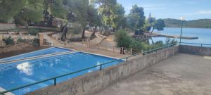 a swimming pool next to a body of water at Mobile home Pirovac in Pirovac +18 photos