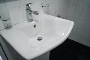 a white sink with a faucet in a bathroom at Mirage Waterfall Villa in Talawakele +40 photos