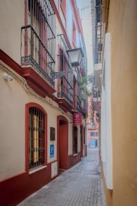 a narrow alley with buildings on a city street at LIRIUM Casa Patio in Seville
