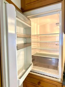 un réfrigérateur vide avec sa porte ouverte dans une cuisine dans l'établissement Apartment mit Bergblick kostenloser Parkplatz, WLAN, TV, Einbauküche, à Ruhpolding