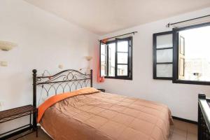 a bedroom with a bed and two windows at Saint Michel Apartments in Rhodes Town