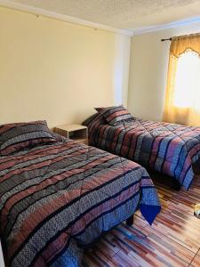 a bedroom with two beds and a window at Departamento amoblado calama in Calama +21 photos