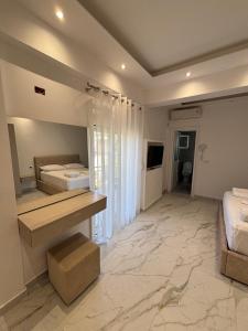 a large room with two beds and a mirror at Harmony Apartments in Dhërmi