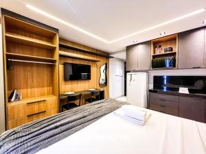 a bedroom with a bed and a refrigerator and cabinets at Edifício Way Tambaú in Tambaú