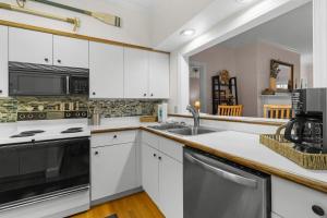 Una cocina con gabinetes blancos y un fregadero. en Golfers Escape 2 Bedroom 2 and Half Baths, en Pawleys Island