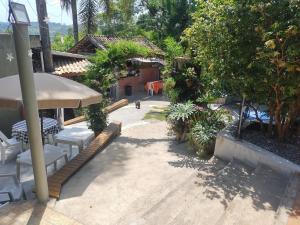 a patio with a table and chairs and a umbrella at Casa de campo rocha in Ribeirão Pires