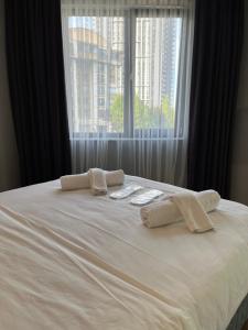 a white bed with two towels on it with a window at Villasuit in Ankara