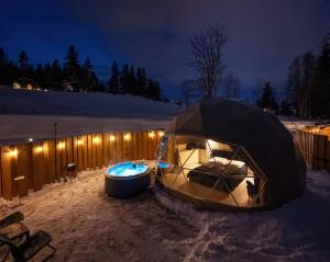 扎科帕内Diamond Glamp & Jacuzzi的夜晚雪地里的帐篷和浴缸