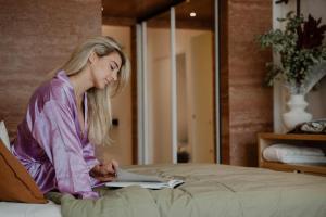 a girl laying on a bed reading a book at Ermou 18 in Athens +15 photos