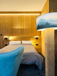 ein Schlafzimmer mit einem Bett und einer großen Lampe in der Unterkunft Le Sacca Hôtel restaurant in Cauterets