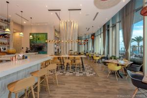 a restaurant with a bar and tables and chairs at Stunning Beachfront 3-Bedroom Corner Residence in Hollywood