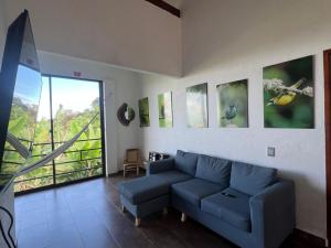 a living room with a blue couch and a window at Campo Bonito in Jericó