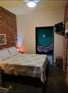a bedroom with a bed and a large screen television at Poente Guest House in Conceição da Ibitipoca