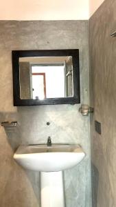 a bathroom with a sink and a mirror at Mango House in Galle +10 photos
