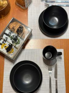 a table with two black plates and a fork and knife at The Little Blooming House in Agíasma +30 photos
