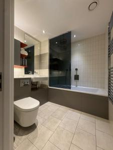 a bathroom with a toilet and a bath tub at Luxury 1 Bedroom Apartment In London with Free parking in London