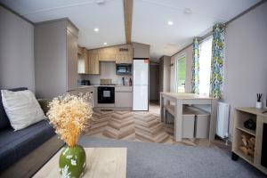 un soggiorno con divano e cucina di Grantown Getaway - SJA Stays - Modern 2 Bed Static a Grantown on Spey