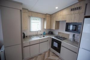 una cucina con lavello e fornello forno superiore di Grantown Getaway - SJA Stays - Modern 2 Bed Static a Grantown on Spey