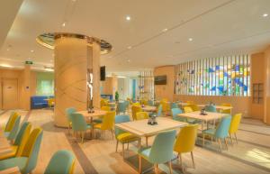 a restaurant with tables and chairs in a room at Holiday Inn Express Shanghai Zhenping, an IHG Hotel in Shanghai
