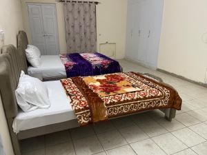 two beds in a room with a blanket on them at upper portion of a house in Islamabad