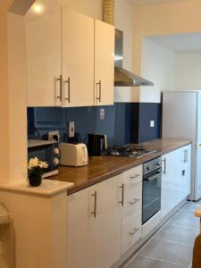 a kitchen with white cabinets and a counter top at 2 Bedroom House in Nottingham