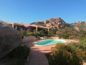 una piscina frente a una casa con montaña en Villetta Sardinia, en Costa Paradiso