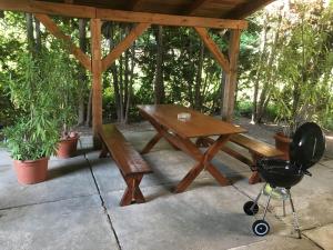 a picnic table and a chair under a pavilion at Balatonföldvar Centrum Apartmanok 2 in Balatonföldvár