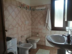 Un baño con un inodoro blanco y un lavabo. en Villetta Sardinia, en Costa Paradiso 39 fotos más