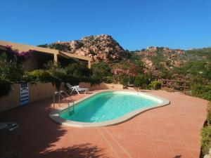 una piscina con una montaña al fondo en Villetta Sardinia, en Costa Paradiso