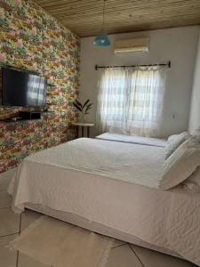 a bedroom with a large bed and a tv at Casa Mathia in Caraíva +13 photos