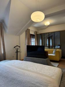 a bedroom with a bed and a living room with a couch at De Luxe Villa in Skopje +3 photos