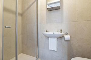 a bathroom with a sink and a shower at Luxury 4-Bed Home Coventry - City Centre with FREE Parking & Garden in Coventry
