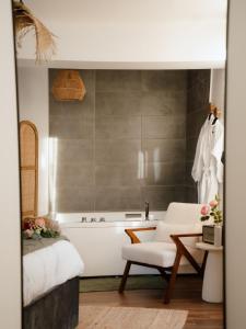 un bagno con vasca, sedia e letto di Suite Cara - Logement Atypique Sauna Balneo - Centre Historique a Brive-la-Gaillarde Altre 20 foto