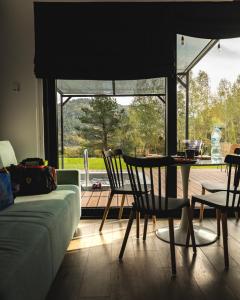 un soggiorno con un divano, un tavolo e delle sedie di Czarna Chata Luxury Resort a Klimkówka