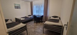 a room with three beds and a desk in it at Ferienwohnung in Krefeld Monteurzimmer Gästezimmer Messezimmer Apartment in Krefeld in Krefeld +3 photos