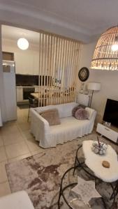 a living room with a white couch and a table at Christi & Paris Nest in Volos