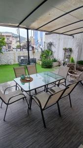 a glass table and chairs on a patio with a view at Christi & Paris Nest in Volos