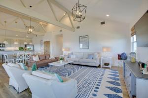 a living room with white furniture and a kitchen at Lakefront NOLA Home with Hot Tub and Views! in New Orleans