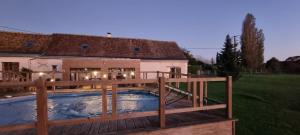 a hot tub on a deck next to a house at CHAMBRES D'HOTES EpLABONNE in Channay-sur-Lathan