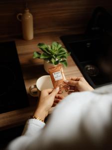 Una donna sta reggendo una scatola di caffè di Suite Cara - Logement Atypique Sauna Balneo - Centre Historique a Brive-la-Gaillarde