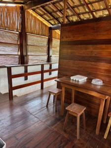 a room with a wooden table and a bench at Igapeba Hospedaria em Moreré in Cairu +22 photos