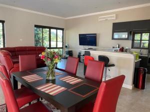 a dining room and kitchen with a table and red chairs at Peaceful picturesque Pecanwood in Hartbeespoort