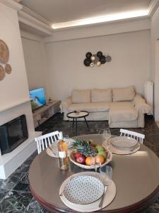 アルカネスにあるΚonaki Apartmentの果物が置かれたテーブルのあるリビングルーム +1枚の写真