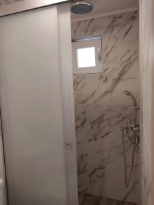 アルカネスにあるΚonaki Apartmentの大理石の壁のバスルーム(シャワー付)が備わります。
