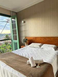 a bed with two towels on it in a bedroom at Pousada Solar dos Guaras in Catas Altas