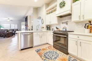 a kitchen with white cabinets and a stove top oven at Desert Oasis with Outdoor Living in Goodyear! in Liberty