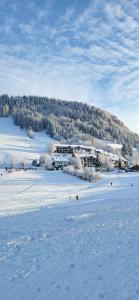 a snow covered field with a building in the background at Ferienhof Rindalphorn mit Sauna in ländlicher Idylle in Missen-Wilhams